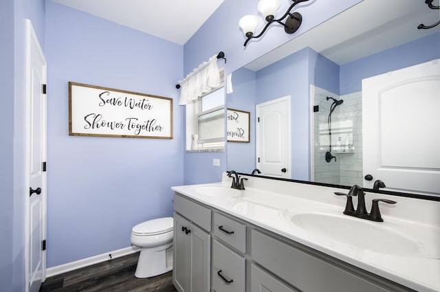 27363 W Macura St, Channahon, IL 60410 - bathroom featuring a tile shower, wood finished floors, toilet, double vanity, and baseboards