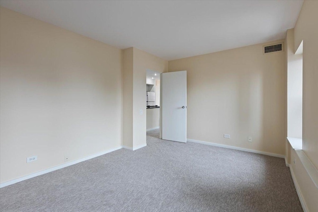 unfurnished room featuring carpet and baseboards