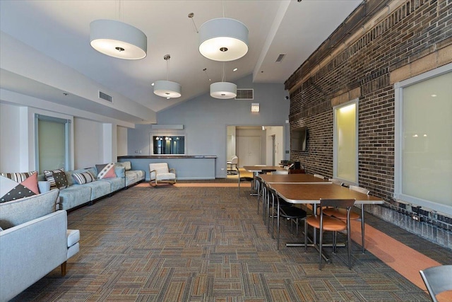 common area featuring brick wall and high vaulted ceiling