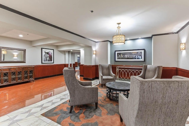 community lobby featuring ornamental molding and a wainscoted wall