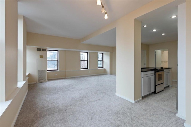unfurnished living room featuring light colored carpet, baseboards, and recessed lighting