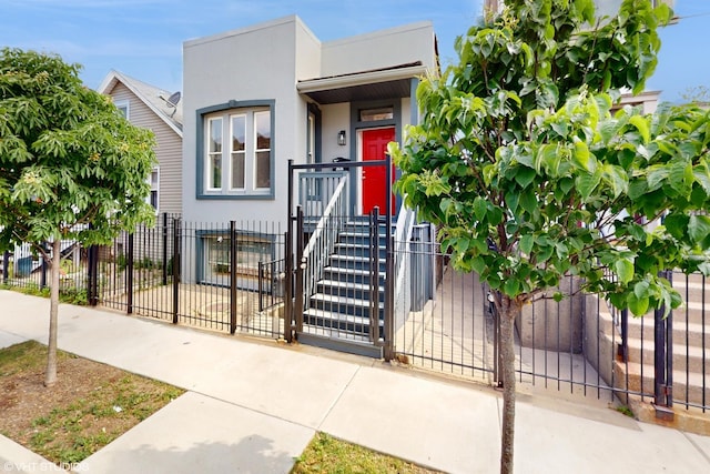 2636 W Grand Ave, Chicago, IL 60612 - view of front of house with stucco siding, a fenced front yard, and a gate