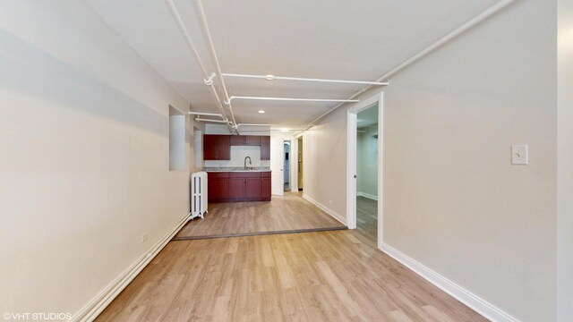 2636 W Grand Ave, Chicago, IL 60612 - hallway with a sink, radiator heating unit, light wood finished floors, baseboards, and recessed lighting