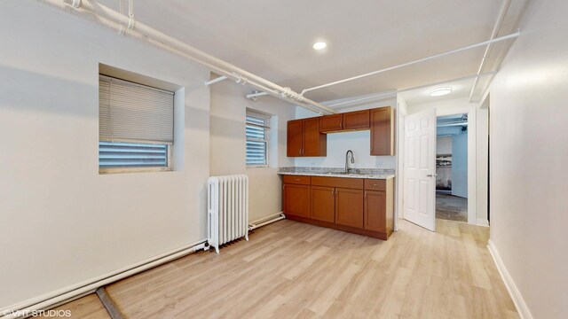 2636 W Grand Ave, Chicago, IL 60612 - kitchen with radiator heating unit, light wood finished floors, brown cabinets, a sink, and recessed lighting