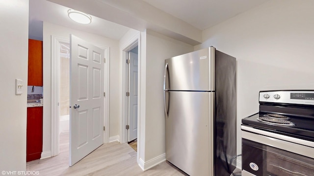 2636 W Grand Ave, Chicago, IL 60612 - kitchen featuring stainless steel appliances, light wood-style floors, and baseboards