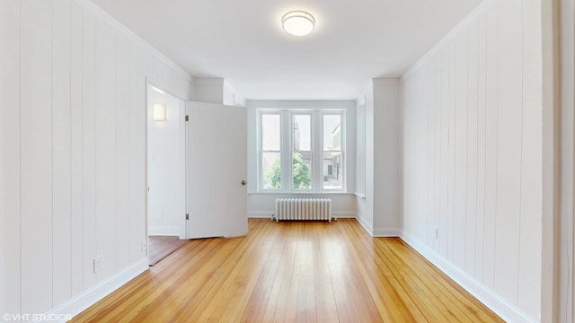 2636 W Grand Ave, Chicago, IL 60612 - empty room featuring radiator heating unit, light wood-type flooring, baseboards, and crown molding