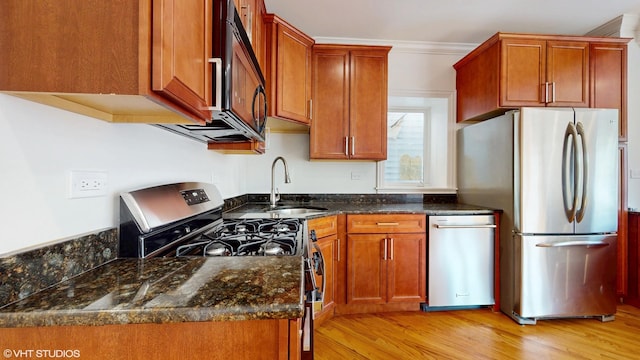 2636 W Grand Ave, Chicago, IL 60612 - kitchen featuring appliances with stainless steel finishes, a sink, light wood finished floors, brown cabinetry, and crown molding