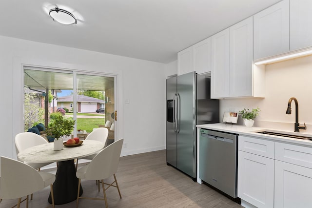 610 Catalpa Ln, Bartlett, IL 60103 - kitchen with stainless steel appliances, a sink, white cabinetry, and light countertops