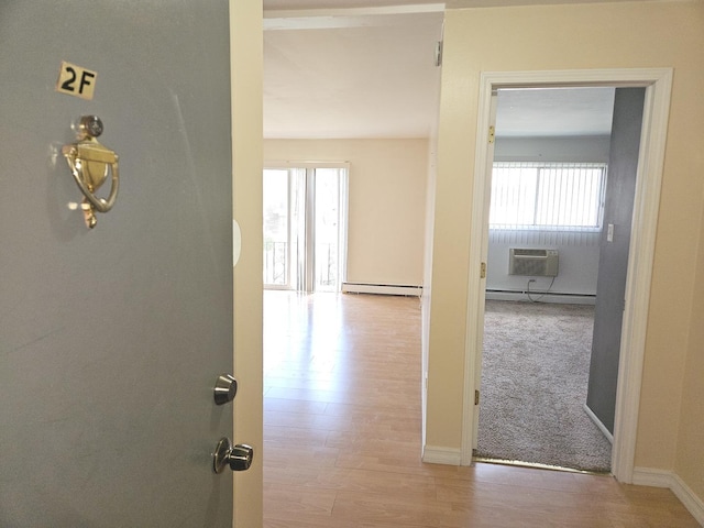 8928 Steven Dr Unit 2F, Des Plaines, IL 60016 - hallway with a baseboard radiator, a wall mounted air conditioner, wood finished floors, and baseboards