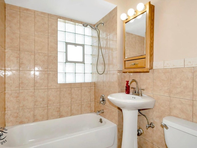 full bathroom with tile walls, shower / tub combination, toilet, and a sink