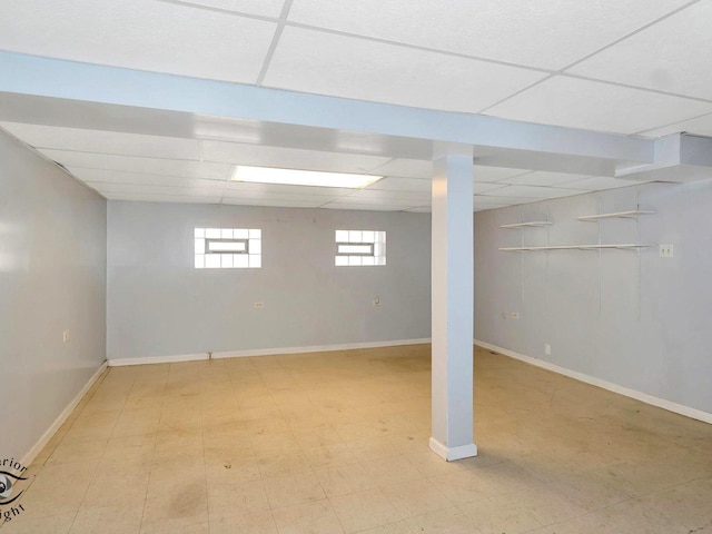 below grade area featuring a drop ceiling and baseboards