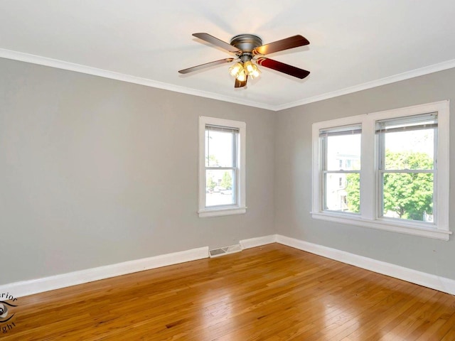 empty room featuring baseboards, wood-type flooring, ornamental molding, and a ceiling fan