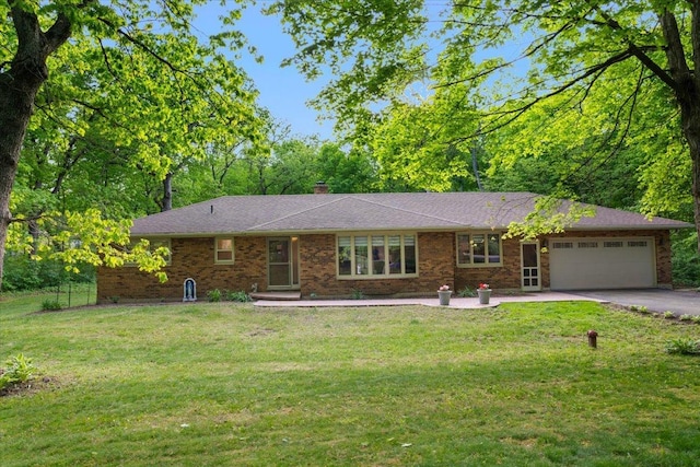 7417 N Hill Rd, Marengo, IL 60152 - ranch-style home featuring an attached garage, asphalt driveway, a front lawn, brick siding, and a chimney