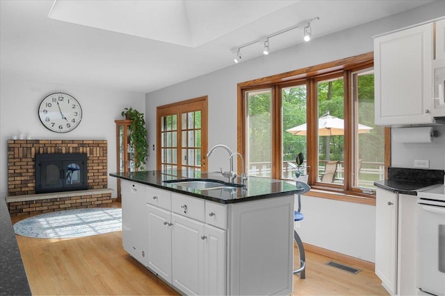 7417 N Hill Rd, Marengo, IL 60152 - kitchen featuring a sink, light wood finished floors, white appliances, and white cabinetry