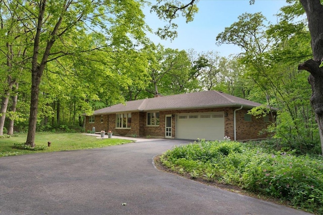 7417 N Hill Rd, Marengo, IL 60152 - ranch-style house featuring a garage, asphalt driveway, brick siding, and a front lawn