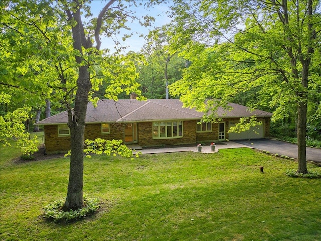 7417 N Hill Rd, Marengo, IL 60152 - ranch-style home featuring asphalt driveway, a front yard, an attached garage, and a chimney