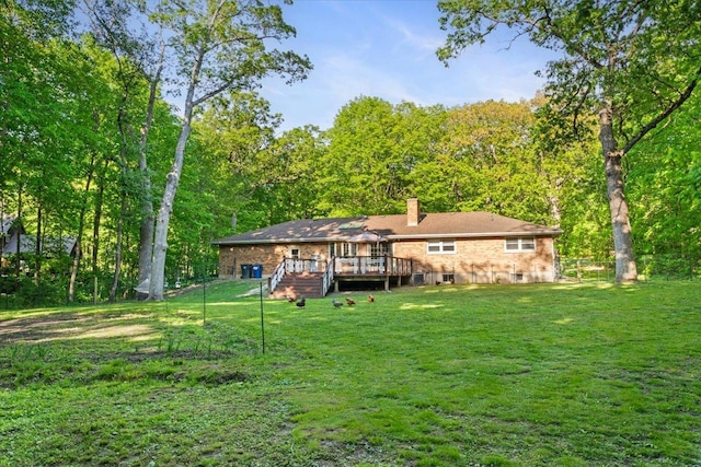 7417 N Hill Rd, Marengo, IL 60152 - rear view of house featuring a deck, a lawn, a chimney, and a view of trees
