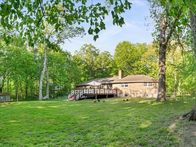 7417 N Hill Rd, Marengo, IL 60152 - rear view of house with a wooden deck, a lawn, a chimney, and an outbuilding