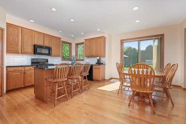 1701 Driftwood Ln, Crystal Lake, IL 60014 - kitchen featuring black appliances, a kitchen island, a breakfast bar, light wood-style flooring, and recessed lighting