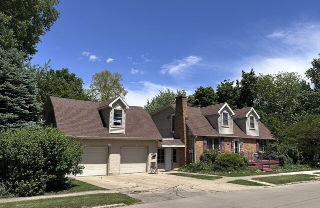 616 E Center St, Ottawa, IL 61350 - new england style home featuring concrete driveway, an attached garage, a shingled roof, brick siding, and a chimney