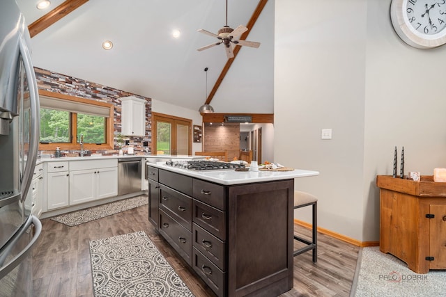 4308 Miller Oaks Dr, Mchenry, IL 60051 - kitchen featuring appliances with stainless steel finishes, white cabinets, light countertops, dark brown cabinets, and a center island