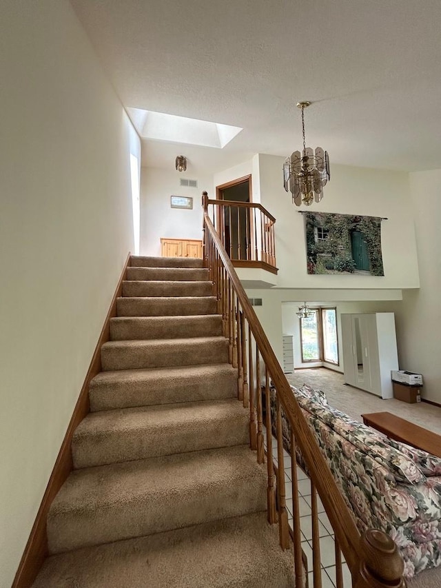 122 San Carlos Rd, Minooka, IL 60447 - stairs featuring carpet floors, a chandelier, a skylight, and tile patterned floors