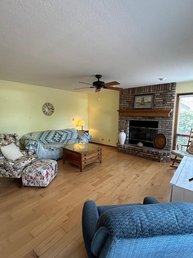 122 San Carlos Rd, Minooka, IL 60447 - living area with wood finished floors, a textured ceiling, ceiling fan, and a fireplace