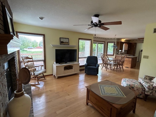 122 San Carlos Rd, Minooka, IL 60447 - living area featuring a fireplace, a ceiling fan, and light wood-style flooring
