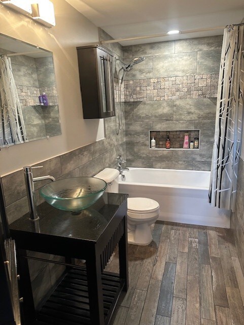 5117 Lear St, Wonder Lake, IL 60097 - full bath featuring wood finished floors, shower / bath combination with curtain, vanity, toilet, and a tiled fireplace