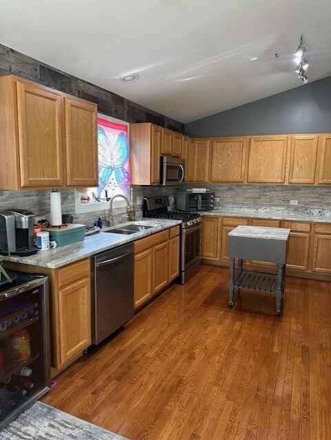 5117 Lear St, Wonder Lake, IL 60097 - kitchen featuring stainless steel appliances, lofted ceiling, a sink, wine cooler, and light countertops