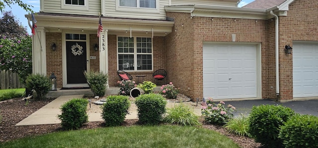 2383 Shiloh Dr, Aurora, IL 60503 - doorway to property with brick siding, covered porch, asphalt driveway, and an attached garage