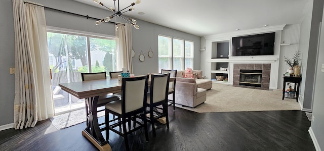 2383 Shiloh Dr, Aurora, IL 60503 - dining room with a tiled fireplace, dark wood-style floors, a chandelier, and built in features