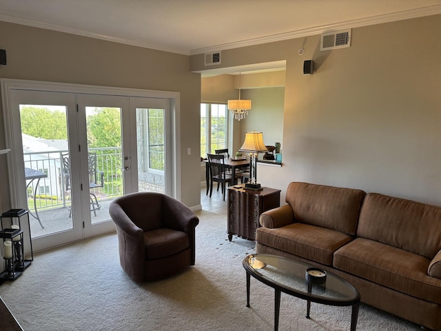 living area with light colored carpet, crown molding, french doors, and a chandelier