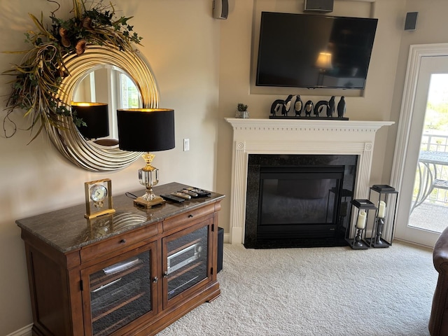 carpeted living area featuring a fireplace with flush hearth and healthy amount of natural light