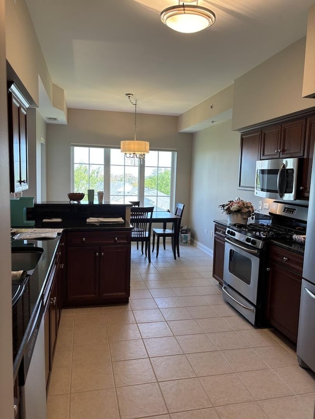 kitchen with stainless steel appliances, light tile patterned floors, dark brown cabinetry, hanging light fixtures, and a chandelier