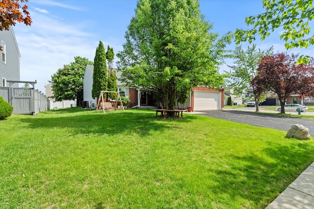 view of yard with a garage and central AC