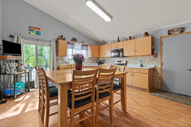 dining area featuring lofted ceiling and light wood-style floors