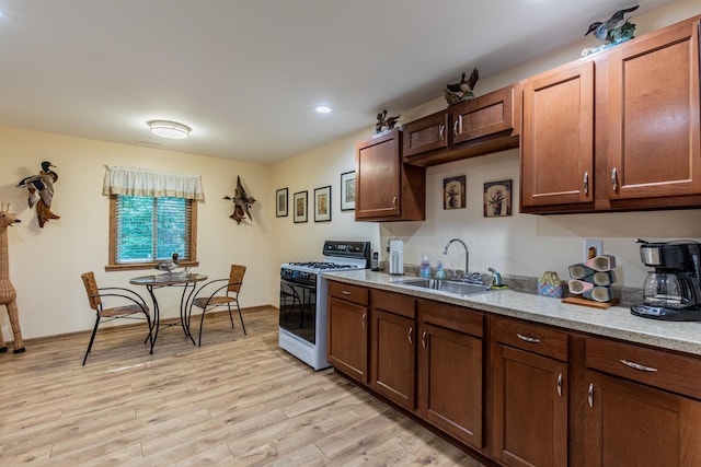 21 Carribean Dr, Putnam, IL 61560 - kitchen with white range with gas cooktop, a sink, light wood-type flooring, light stone countertops, and recessed lighting