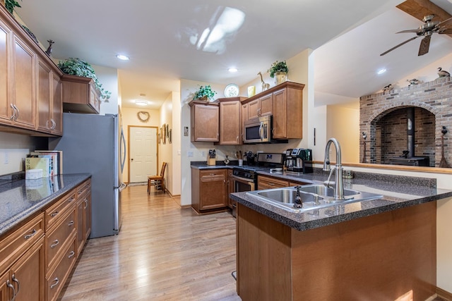 21 Carribean Dr, Putnam, IL 61560 - kitchen with stainless steel appliances, a sink, a wood stove, light wood-style floors, and a ceiling fan