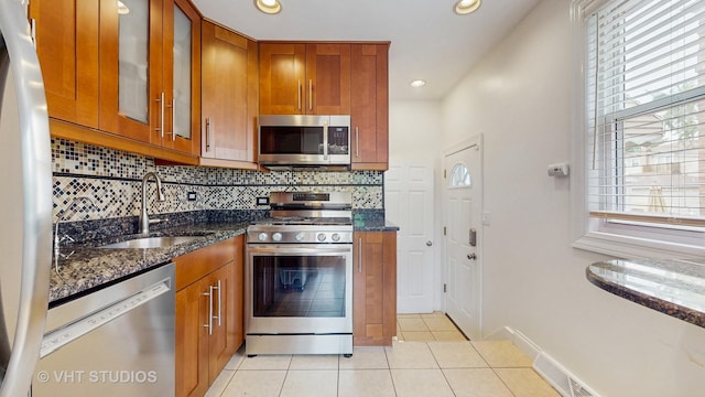 5304 N Oriole Ave, Chicago, IL 60656 - kitchen with stainless steel appliances, brown cabinetry, a sink, dark stone countertops, and recessed lighting