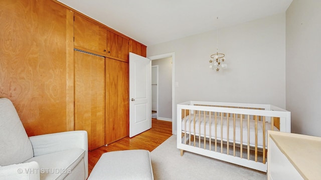 5304 N Oriole Ave, Chicago, IL 60656 - bedroom featuring light wood-style flooring, a closet, a chandelier, and a nursery area
