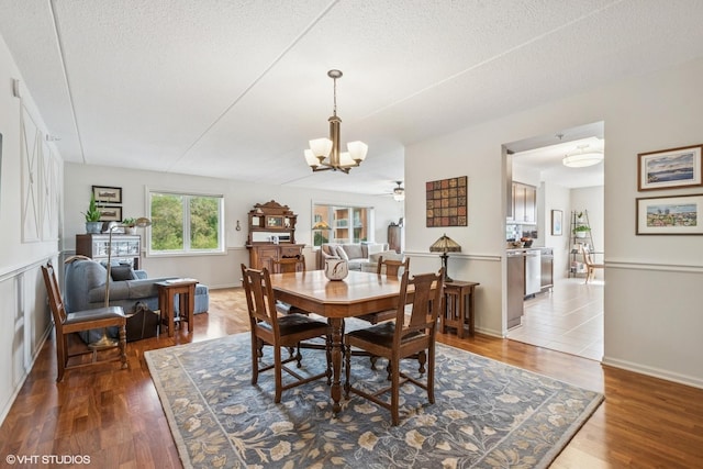6807 N Milwaukee Ave Unit 204, Niles, IL 60714 - dining space featuring a chandelier, wood finished floors, a textured ceiling, and a ceiling fan