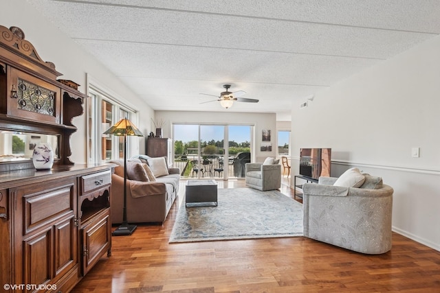 6807 N Milwaukee Ave Unit 204, Niles, IL 60714 - living area featuring wood finished floors, a textured ceiling, and a ceiling fan