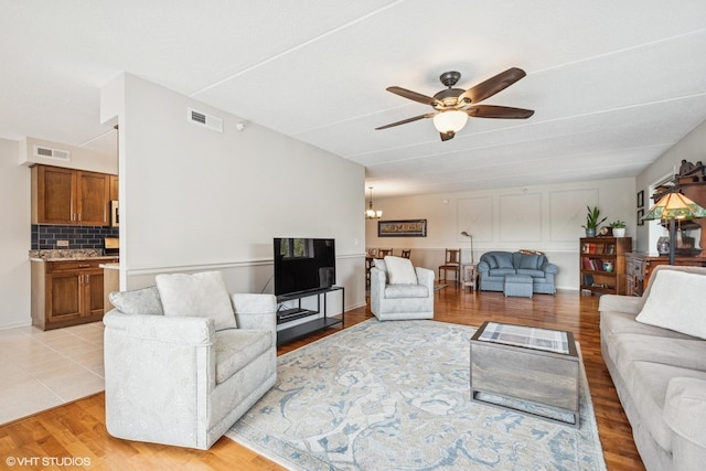 6807 N Milwaukee Ave Unit 204, Niles, IL 60714 - living area with a ceiling fan, a chandelier, and light wood finished floors
