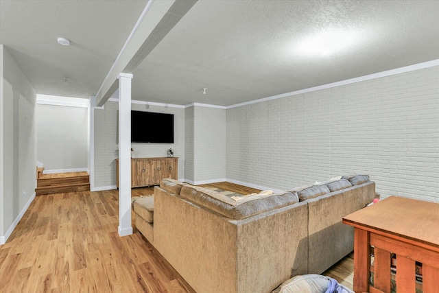 1228 N County Road 530 Rd E, Tuscola, IL 61953 - living room featuring light wood finished floors, brick wall, ornamental molding, and a textured ceiling