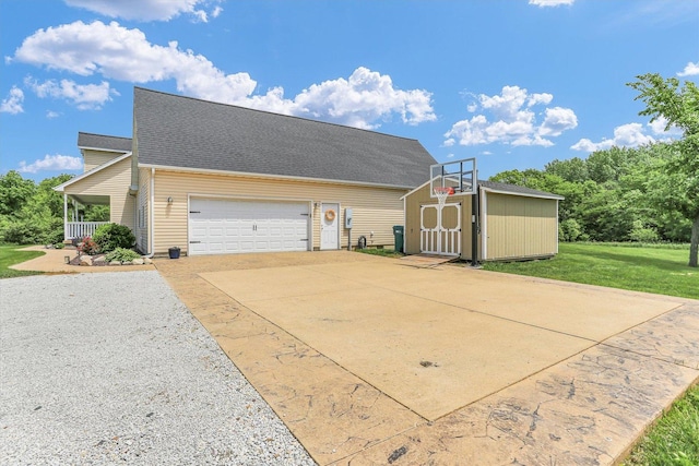 1228 N County Road 530 Rd E, Tuscola, IL 61953 - view of side of home with a storage unit, an attached garage, concrete driveway, a yard, and covered porch