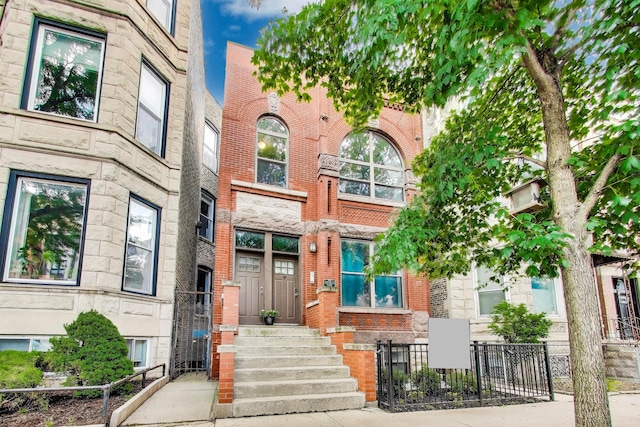 847 N Damen Ave Unit 2R, Chicago, IL 60622 - view of front facade featuring a fenced front yard, stone siding, and brick siding