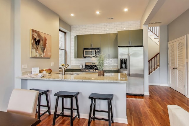 847 N Damen Ave Unit 2R, Chicago, IL 60622 - kitchen with stainless steel appliances, a kitchen bar, dark wood finished floors, a peninsula, and recessed lighting