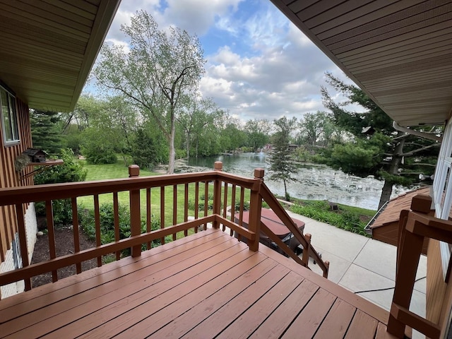 wooden terrace with a water view and view of scattered trees