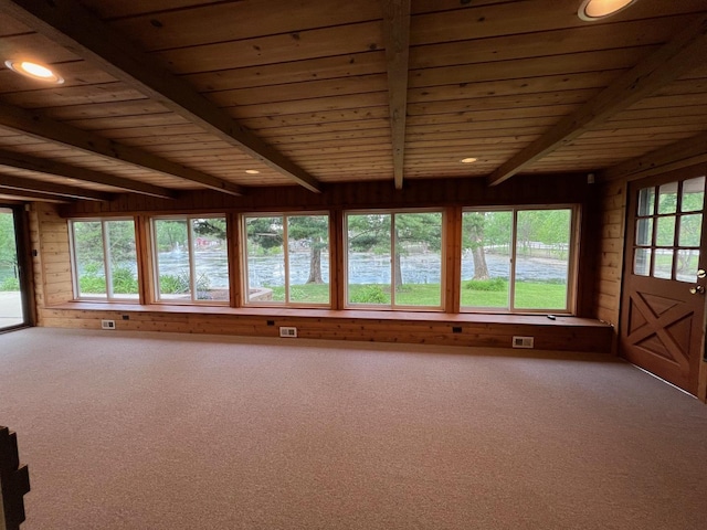 unfurnished sunroom with beamed ceiling, wooden ceiling, wood walls, and carpet floors